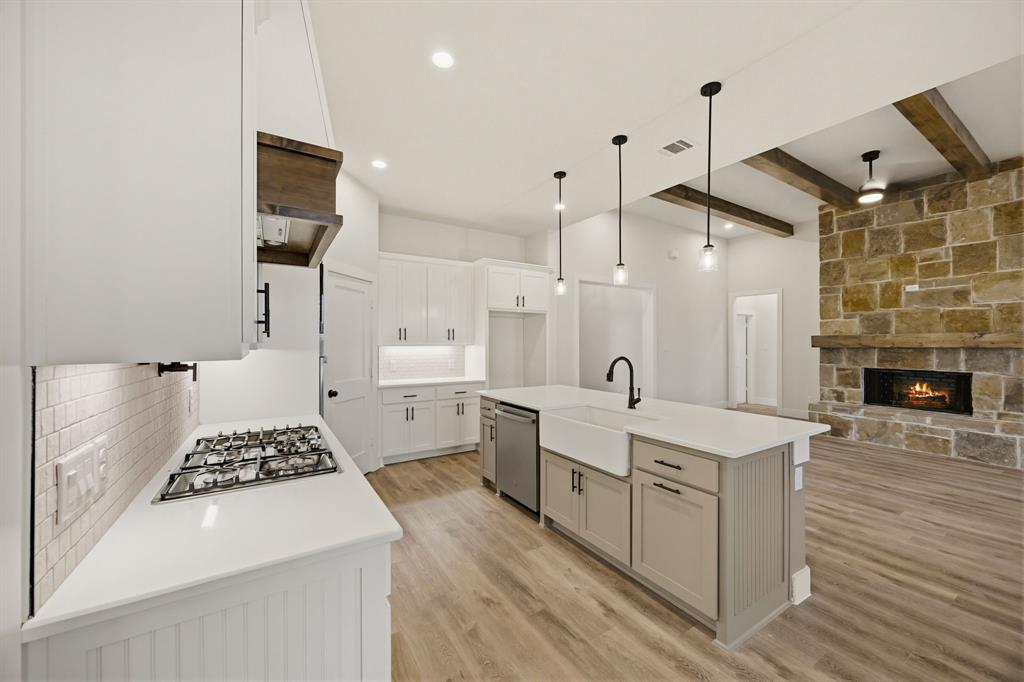 6713 Odom Road Sanger, TX 76266 - Photo 7 of 32 a large white kitchen with a large window a stove a sink and a refrigerator
