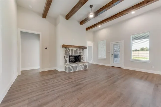 a view of empty room with wooden floor and fireplace