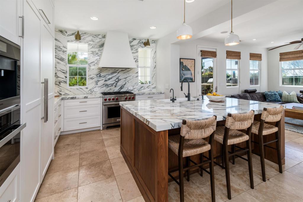 2367 Lapis Road Carlsbad, CA 92009 - Photo 14 of 58 a kitchen with kitchen island granite countertop wooden cabinets and white appliances