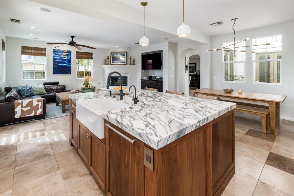 2367 Lapis Road Carlsbad, CA 92009 - Photo 16 of 58 a kitchen with kitchen island granite countertop a stove top oven a sink dishwasher a dining table and chairs with wooden floor