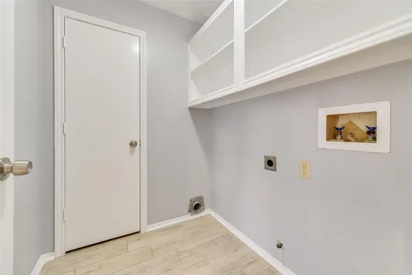 an empty room with wooden floor ceiling fan and windows