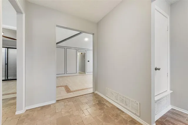 a view of empty room with wooden floor and fireplace