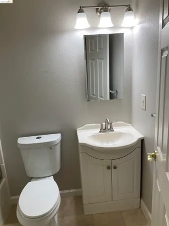 a bathroom with a toilet a sink and mirror
