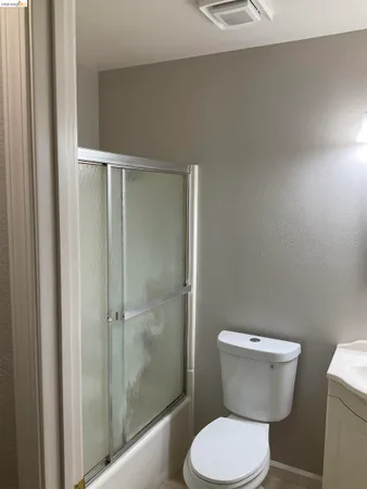 a white toilet sitting next to a shower