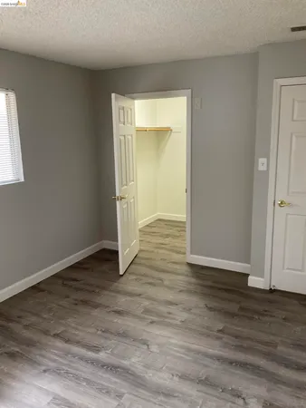 an empty room with wooden floor and closet