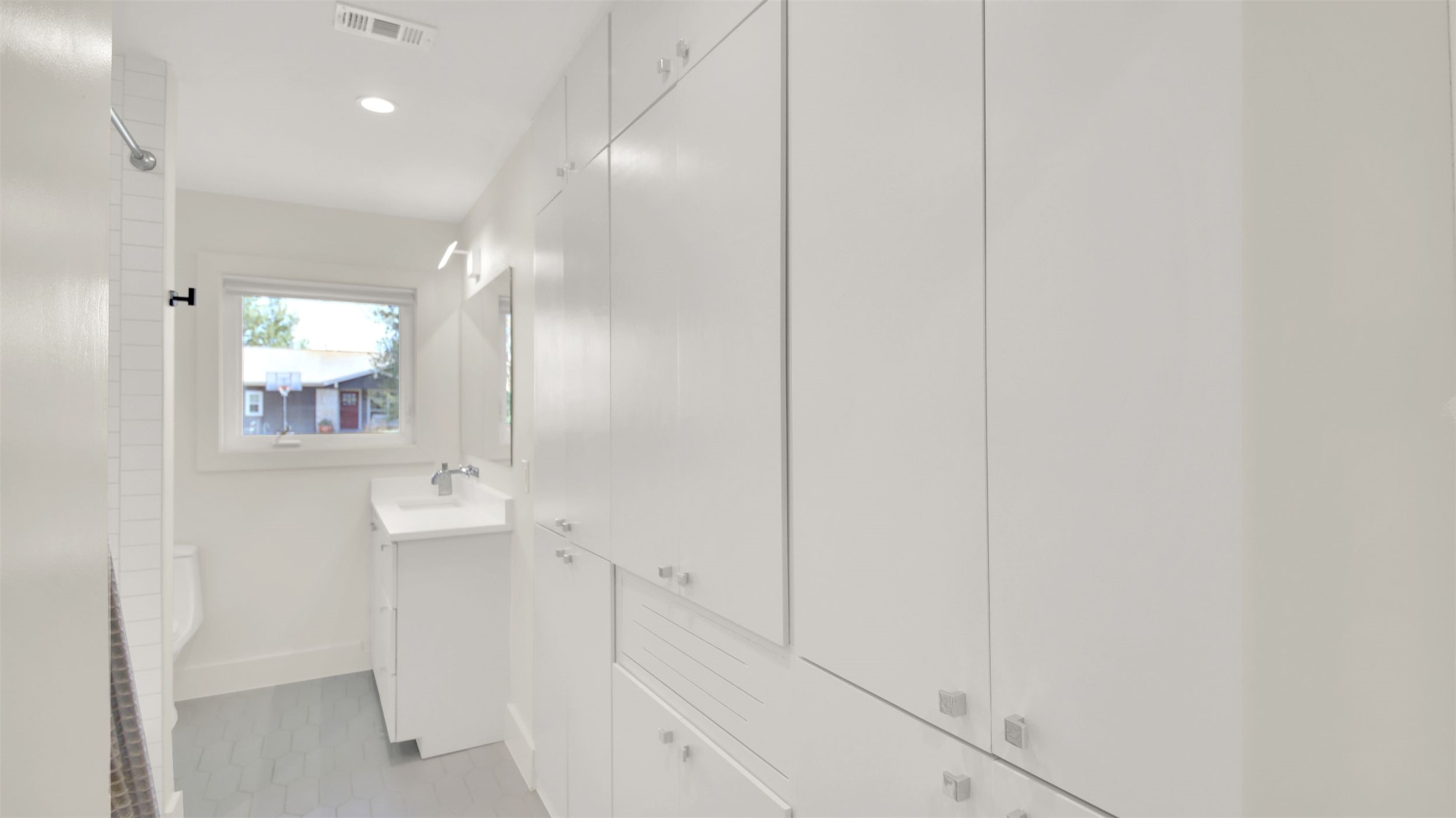 7510 Daugherty Street Austin, TX 78757 - Photo 13 of 37 Bathroom featuring vanity, a shower, recessed lighting, light tile patterned floors, and a closet