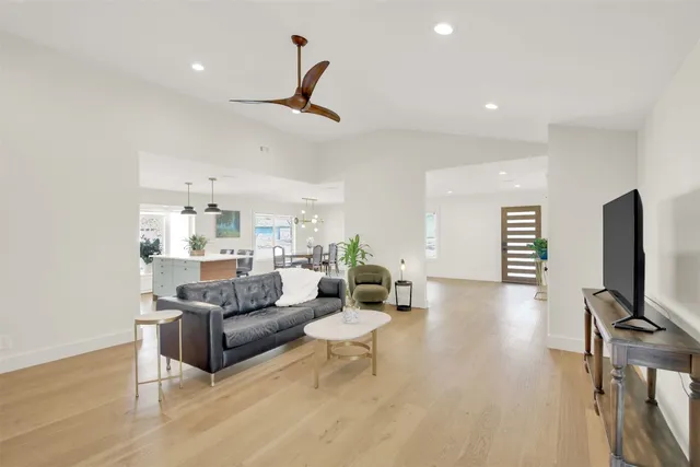 a living room with furniture a flat screen tv and a wooden floor
