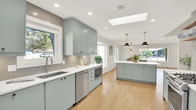 a kitchen with stainless steel appliances a refrigerator sink and stove