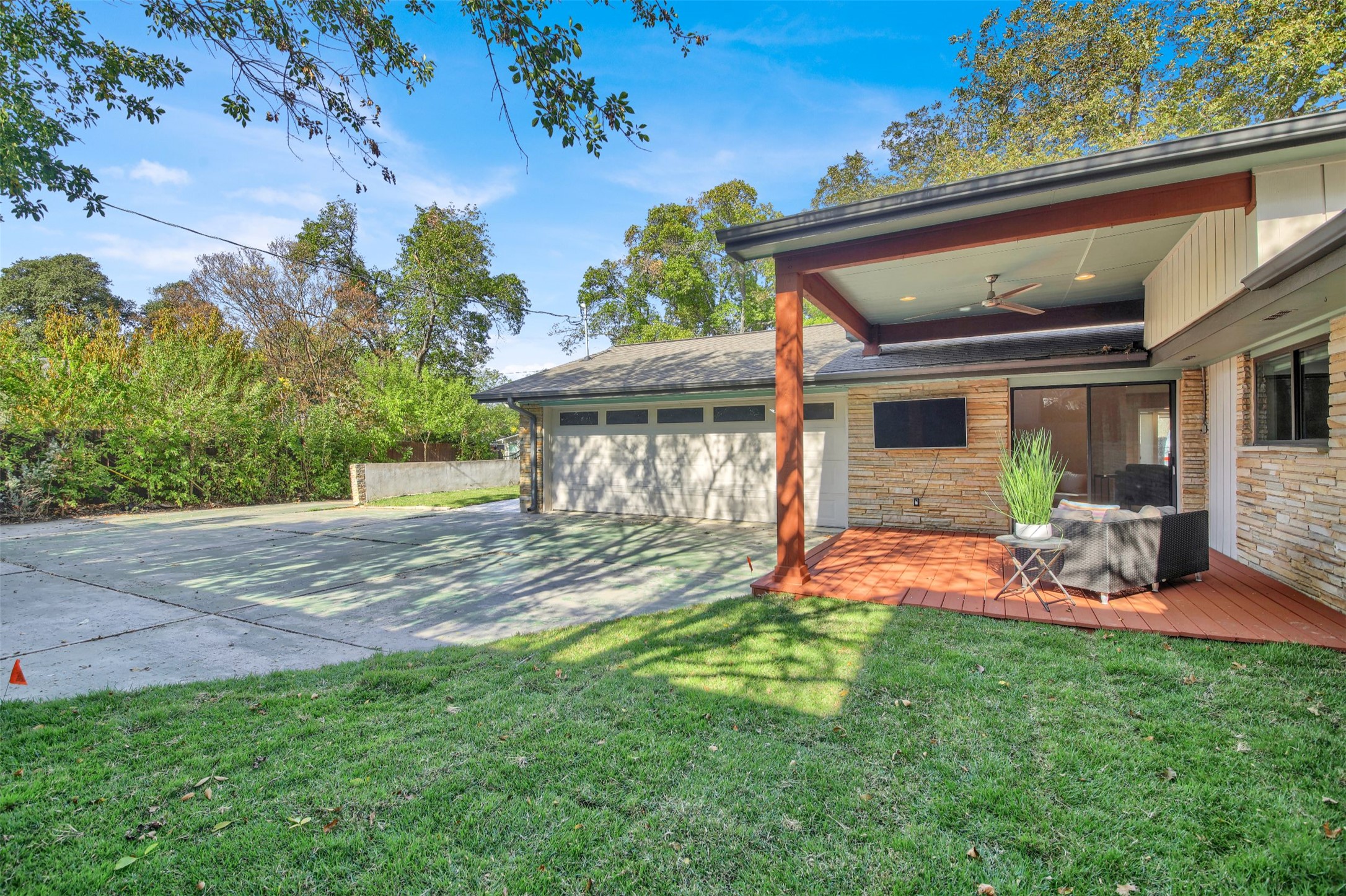 7510 Daugherty Street Austin, TX 78757 - Photo 20 of 37 View of yard with ceiling fan, concrete driveway, and an attached garage