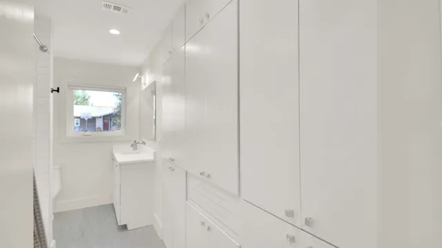 an empty room with windows and ceiling fan