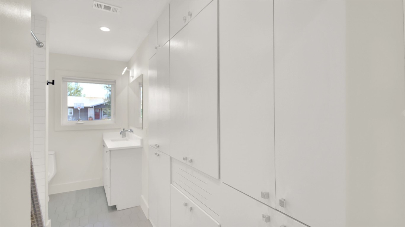 7510 Daugherty Street Austin, TX 78757 - Photo 22 of 37 Bathroom featuring vanity, a shower, recessed lighting, light tile patterned floors, and a closet