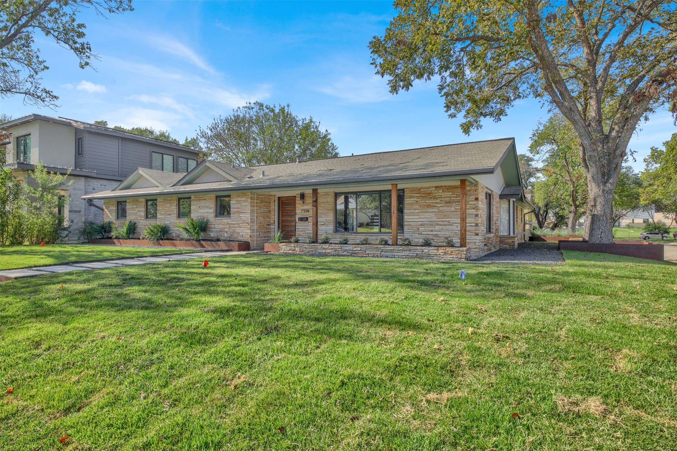 7510 Daugherty Street Austin, TX 78757 - Photo 3 of 37 View of front of property with a front lawn and stone siding