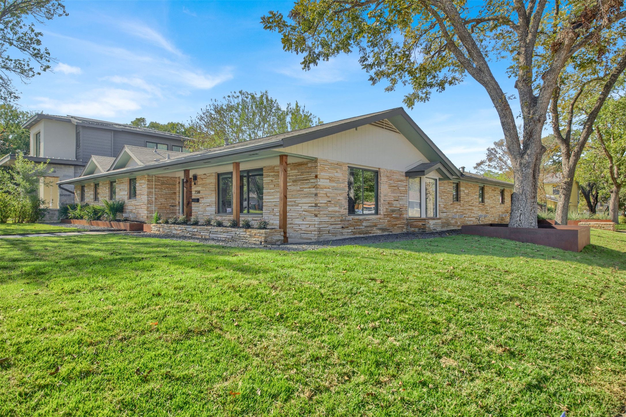 7510 Daugherty Street Austin, TX 78757 - Photo 4 of 37 View of front of property featuring a front yard, a porch, and stone siding