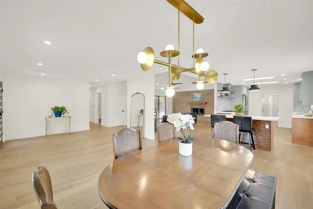 a dining room filled chandelier and kitchen view