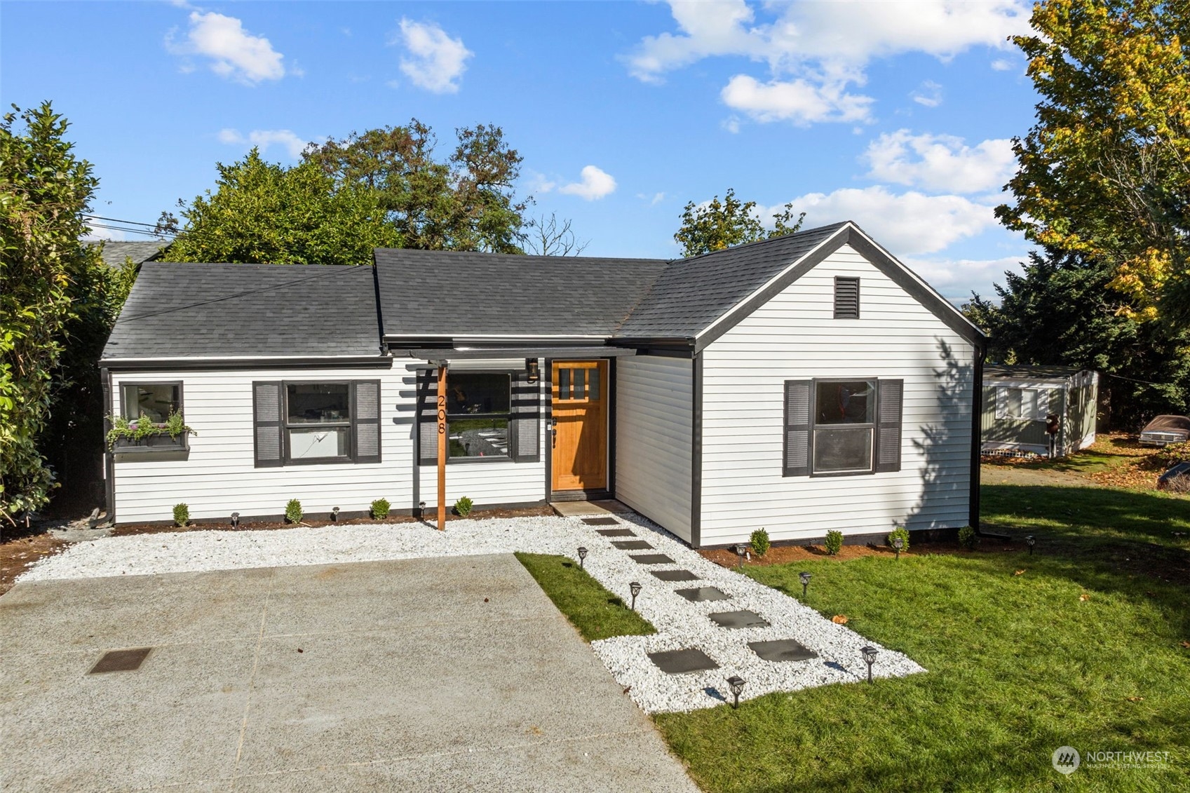 a front view of a house with a garden and yard