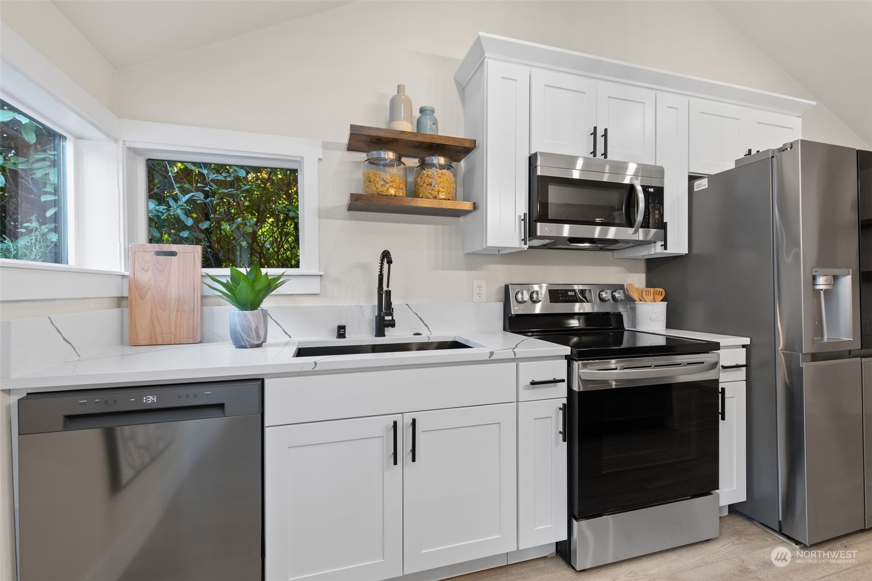 208 South 101st Street Seattle, WA 98168 - Photo 9 of 37 a kitchen with white cabinets and stainless steel appliances