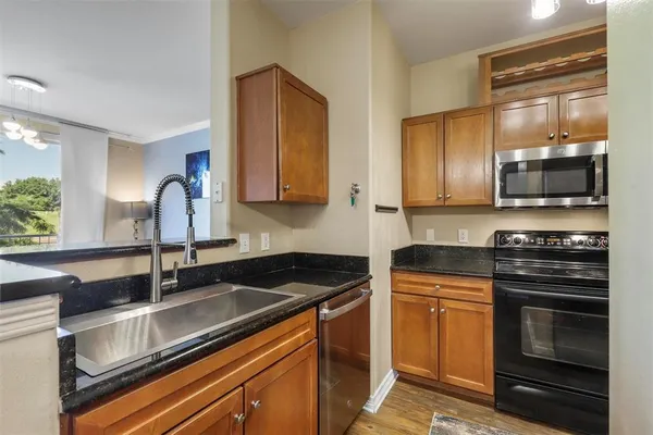 a kitchen with stainless steel appliances granite countertop a sink stove and microwave