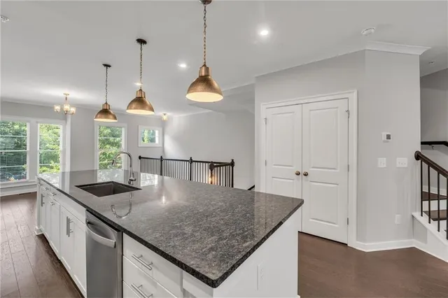 a open kitchen with stainless steel appliances granite countertop a sink a stove and a wooden floors