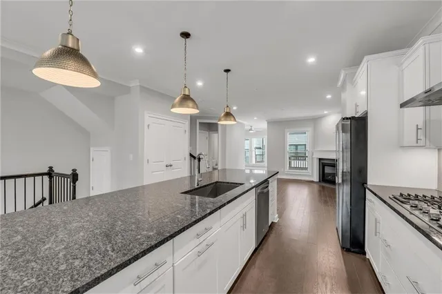 a kitchen with stainless steel appliances granite countertop a sink stove and cabinets