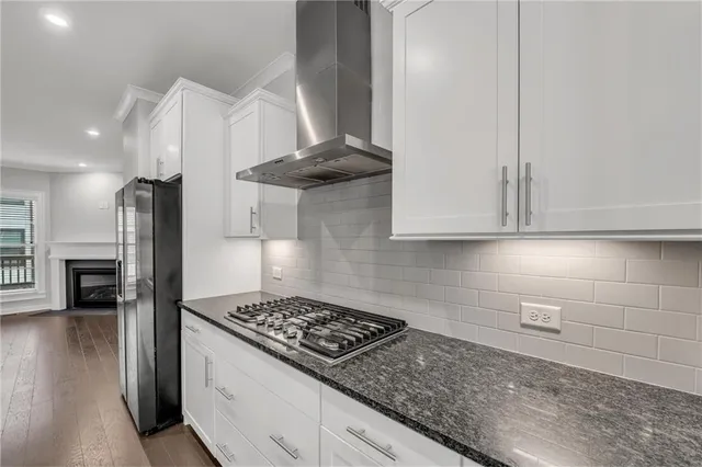 an empty room with wooden floor fireplace and windows