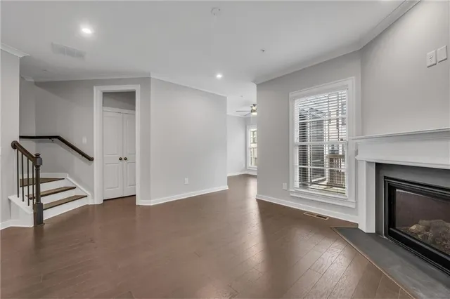 a view of an empty room with kitchen and fireplace