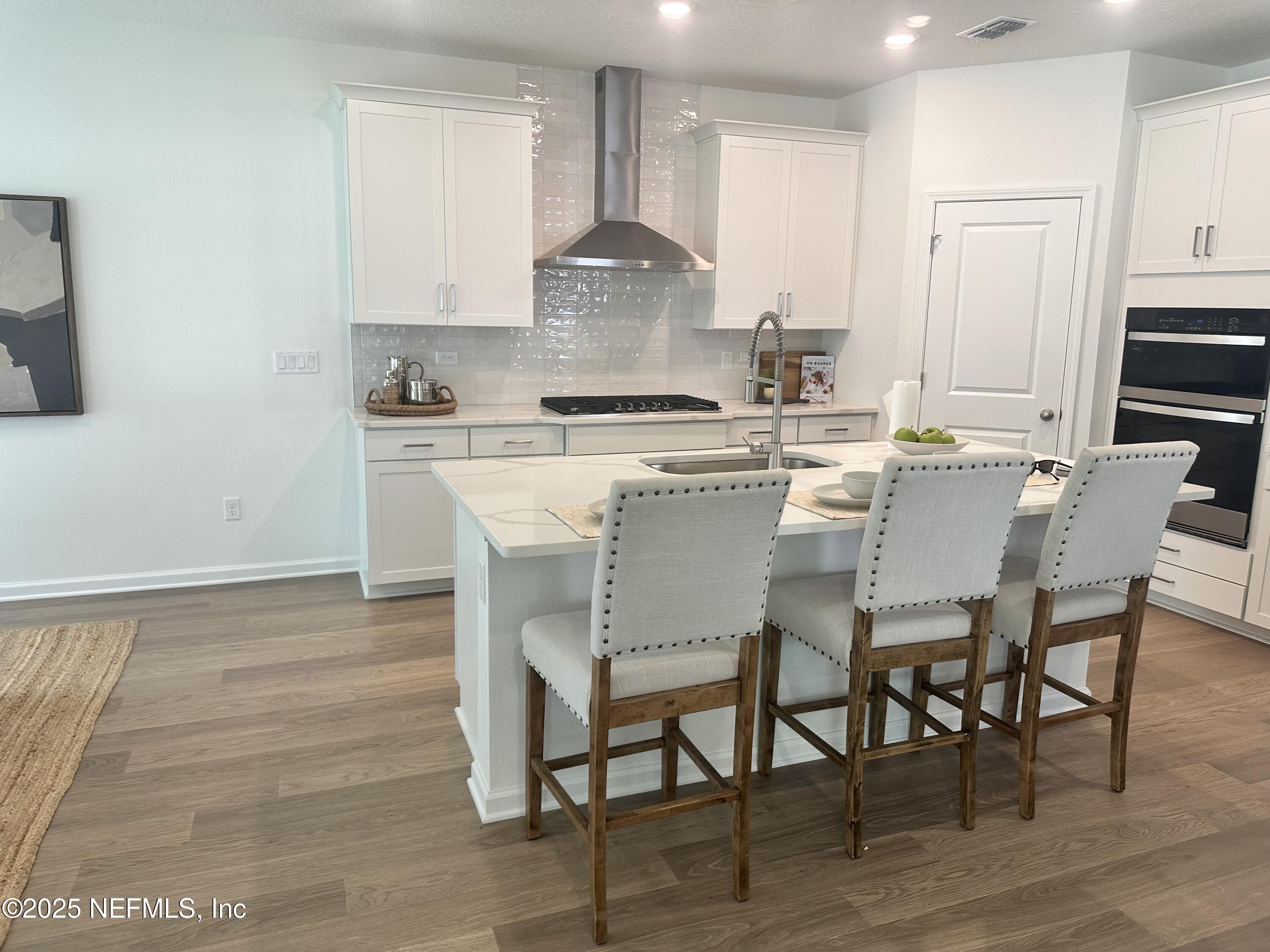 34 Twilight Lane St. Augustine, FL 32095 - Photo 5 of 20 a kitchen with stainless steel appliances granite countertop a table chairs stove and white cabinets