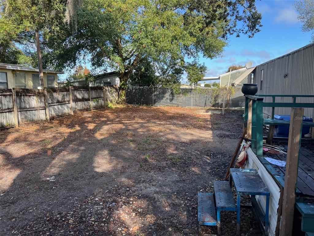 6631 Celeste Lane New Port Richey, FL 34653 - Photo 4 of 13 a backyard of a house with barbeque oven and table and chairs
