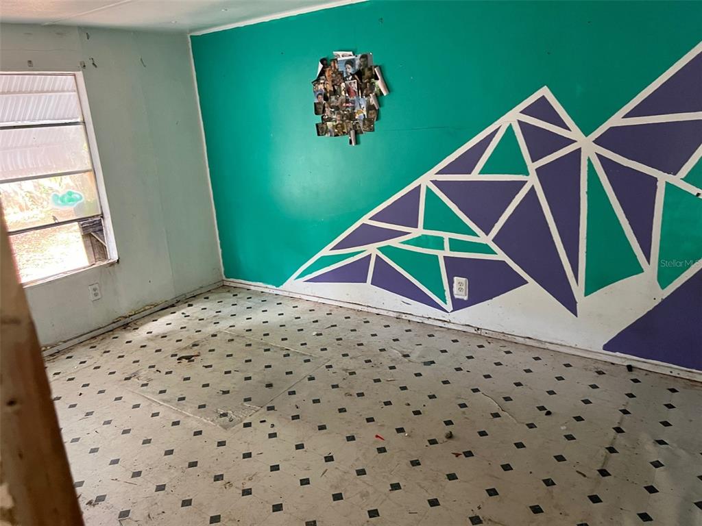 6631 Celeste Lane New Port Richey, FL 34653 - Photo 9 of 13 a bedroom with a bed and a painting on the wall