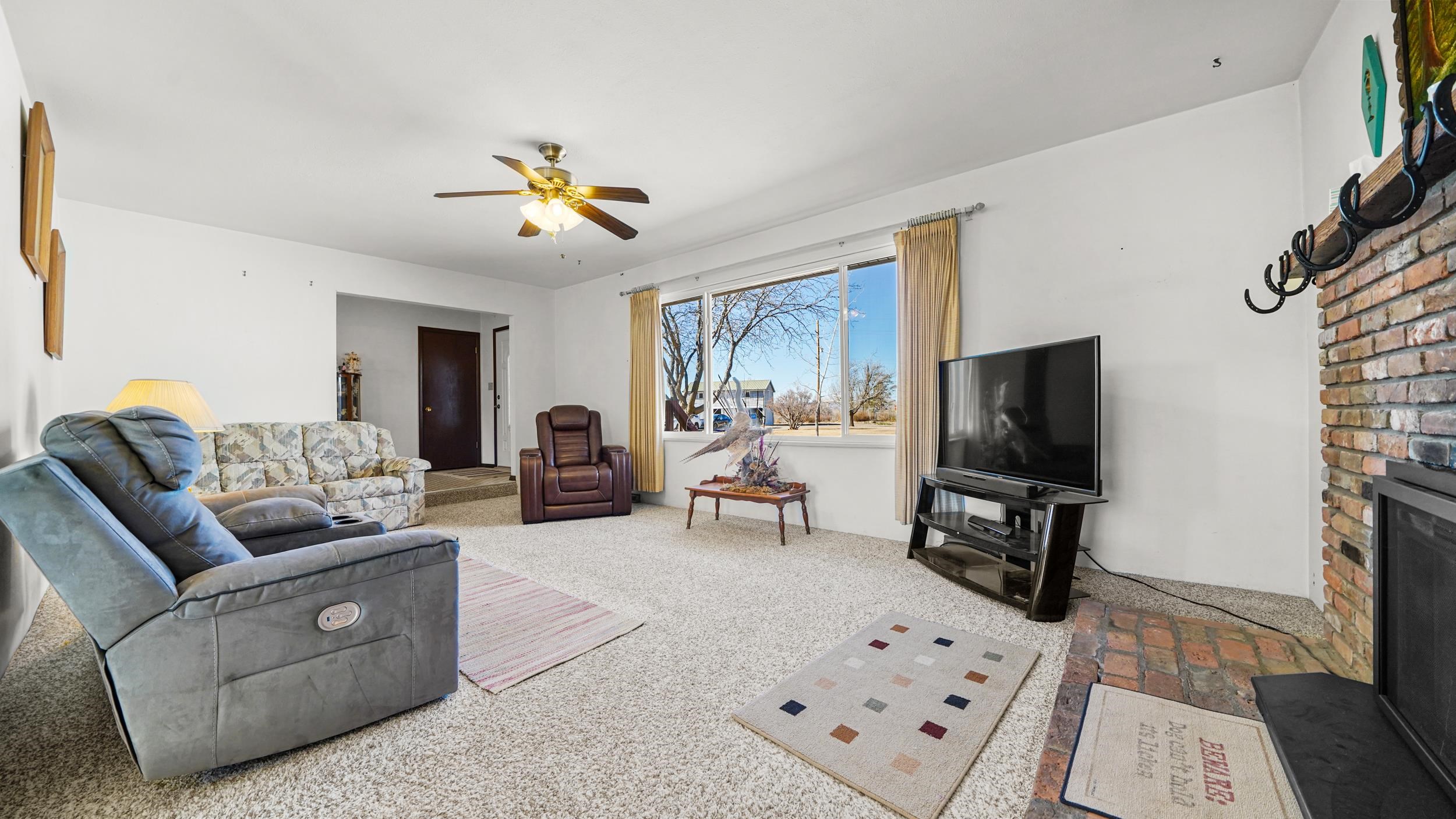 582 36 Road Palisade, CO 81526 - Photo 6 of 31 a living room with furniture a flat screen tv and a refrigerator