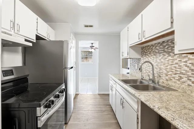 a kitchen with granite countertop a sink and a stove