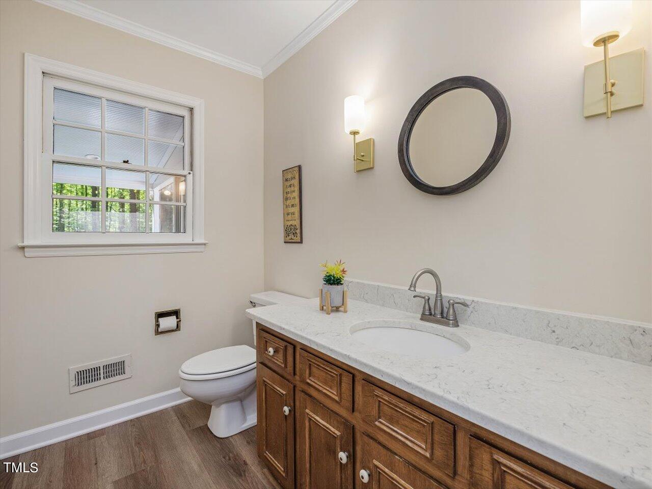 10609 Chinkapin Place Raleigh, NC 27613 - Photo 34 of 78 a bathroom with a toilet a sink and a mirror