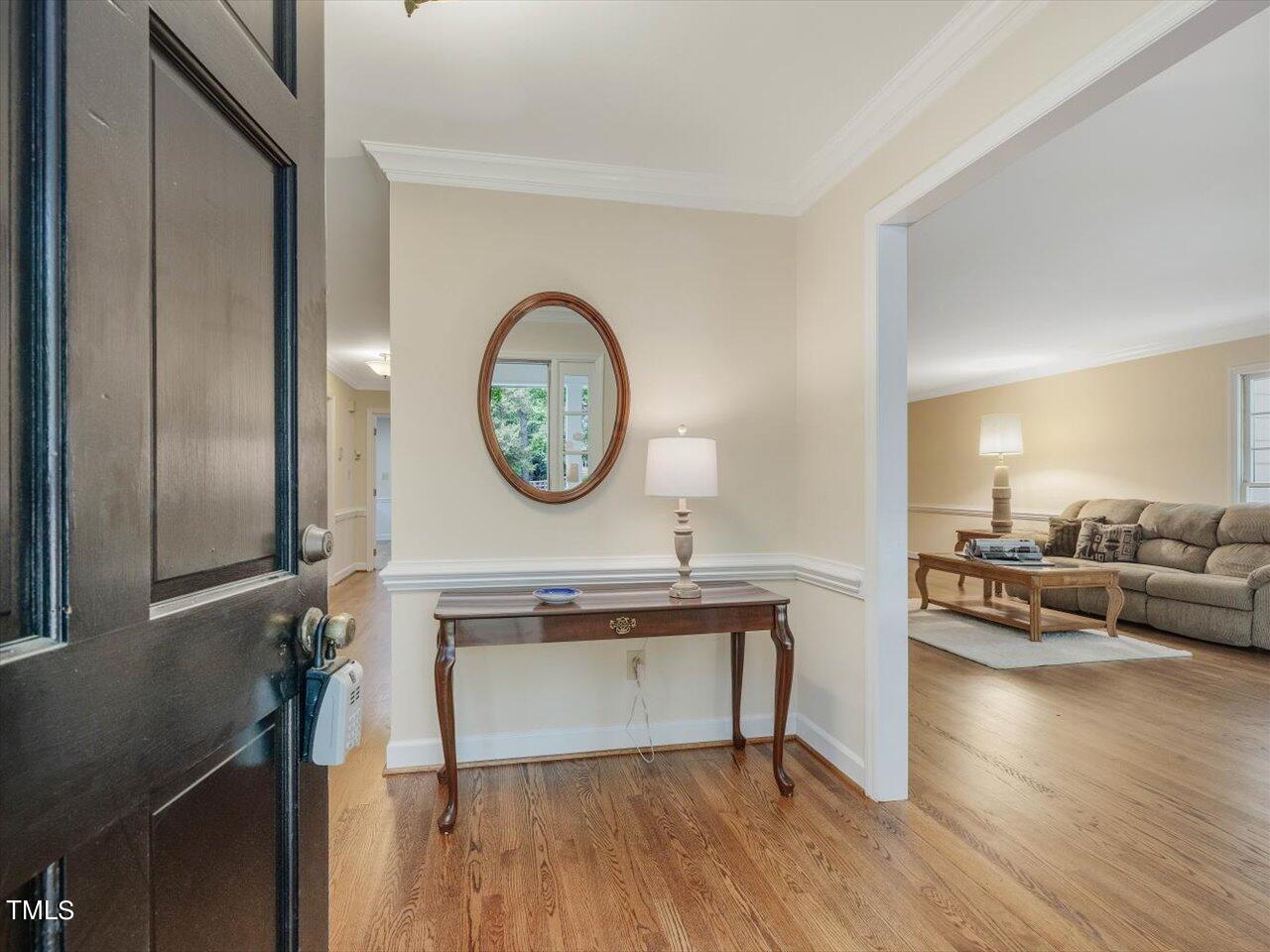 10609 Chinkapin Place Raleigh, NC 27613 - Photo 6 of 78 a living room with furniture a mirror and wooden floor