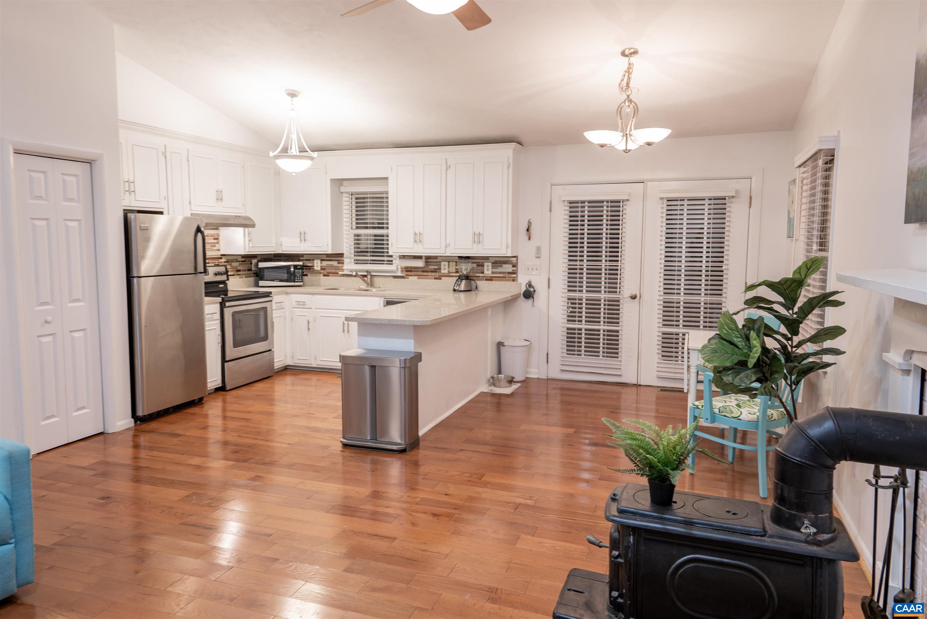 21 Rowell Road Palmyra, VA 22963 - Photo 12 of 30 a kitchen with stainless steel appliances granite countertop a refrigerator a stove a sink dishwasher a oven a dining table and chairs with wooden floor