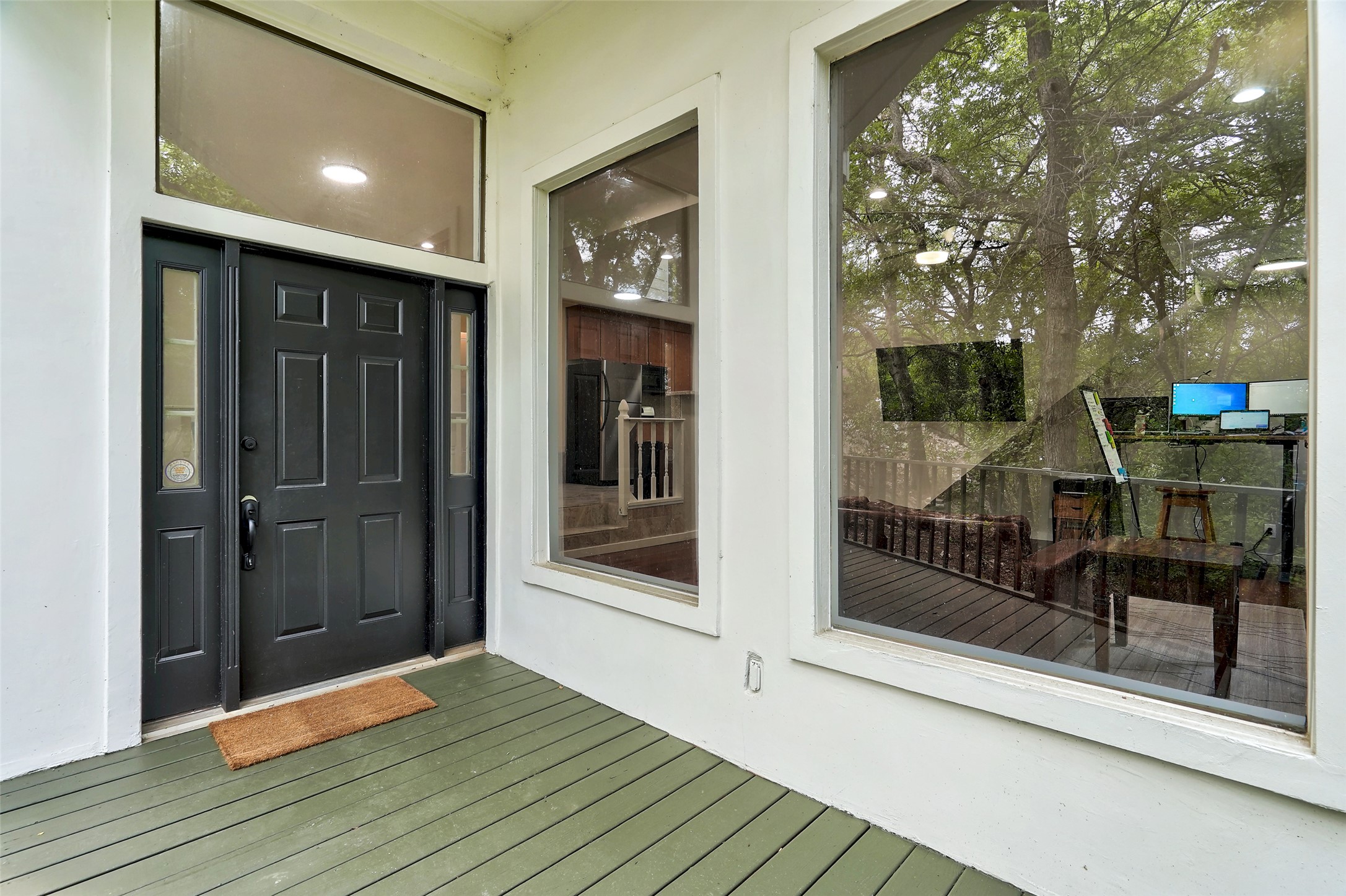 8804 Mountain Ridge Drive, Unit B Austin, TX 78759 - Photo 2 of 17 A dark paneled front door with side and overhead windows, all set against a clean white exterior.