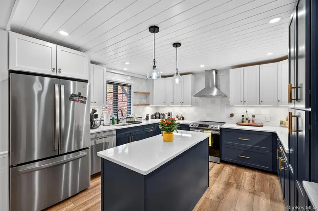 a kitchen with a refrigerator a sink dishwasher a stove and white cabinets with wooden floor