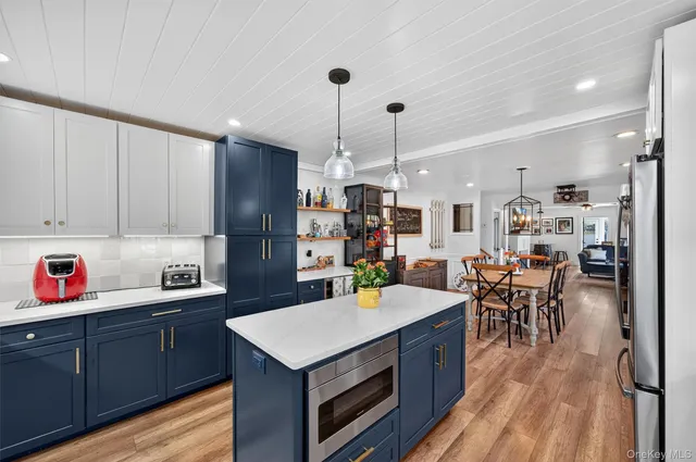 a kitchen with a refrigerator a stove and wooden floor