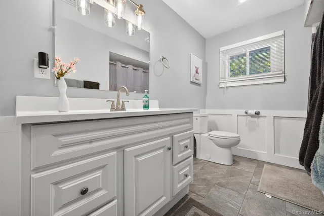 a bathroom with a sink toilet and mirror