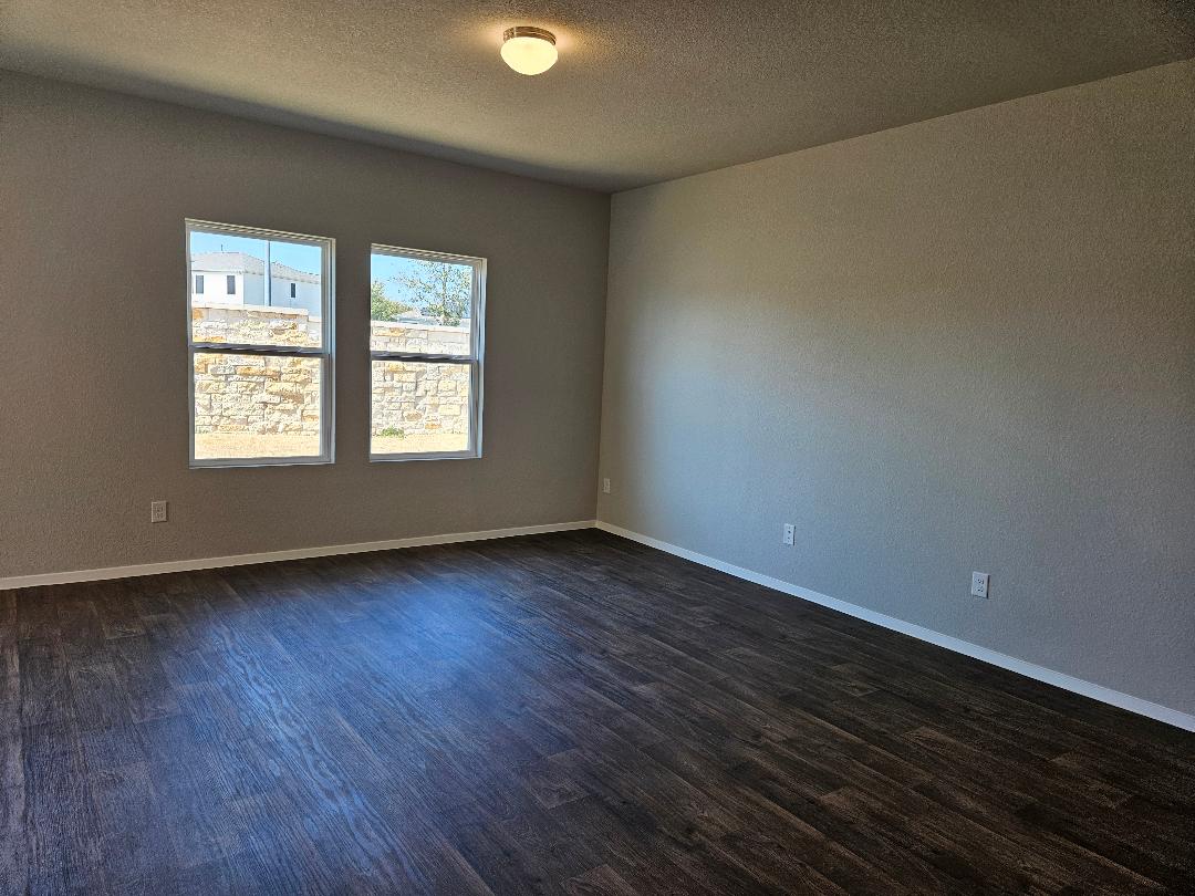 162 Hayloft Lane Elgin, TX 78621 - Photo 2 of 26 an empty room with wooden floor and windows