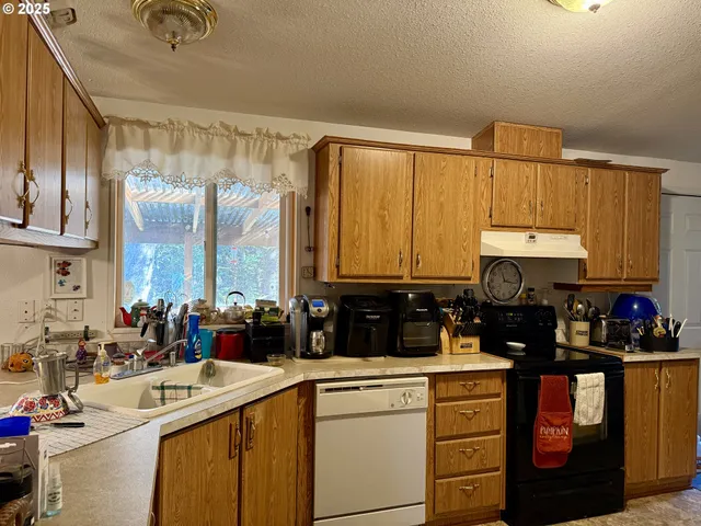 a kitchen with kitchen island granite countertop a sink stainless steel appliances and cabinets