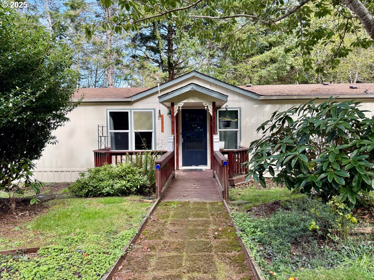 1305 Kristi Loop Lakeside, OR 97449 - Photo 2 of 25 a view of a house with a small yard plants and large tree