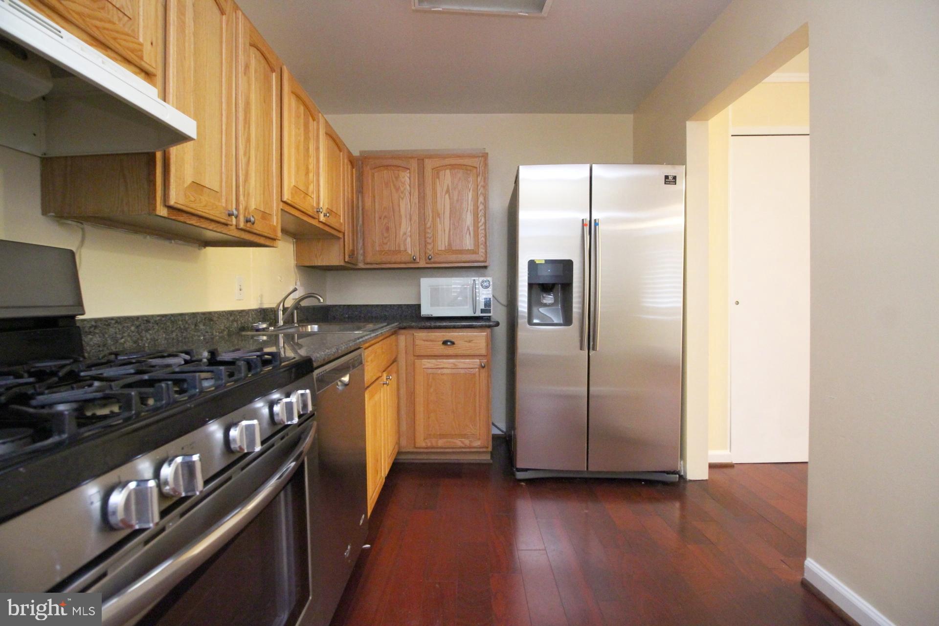 a kitchen with stainless steel appliances granite countertop a stove a refrigerator and a sink