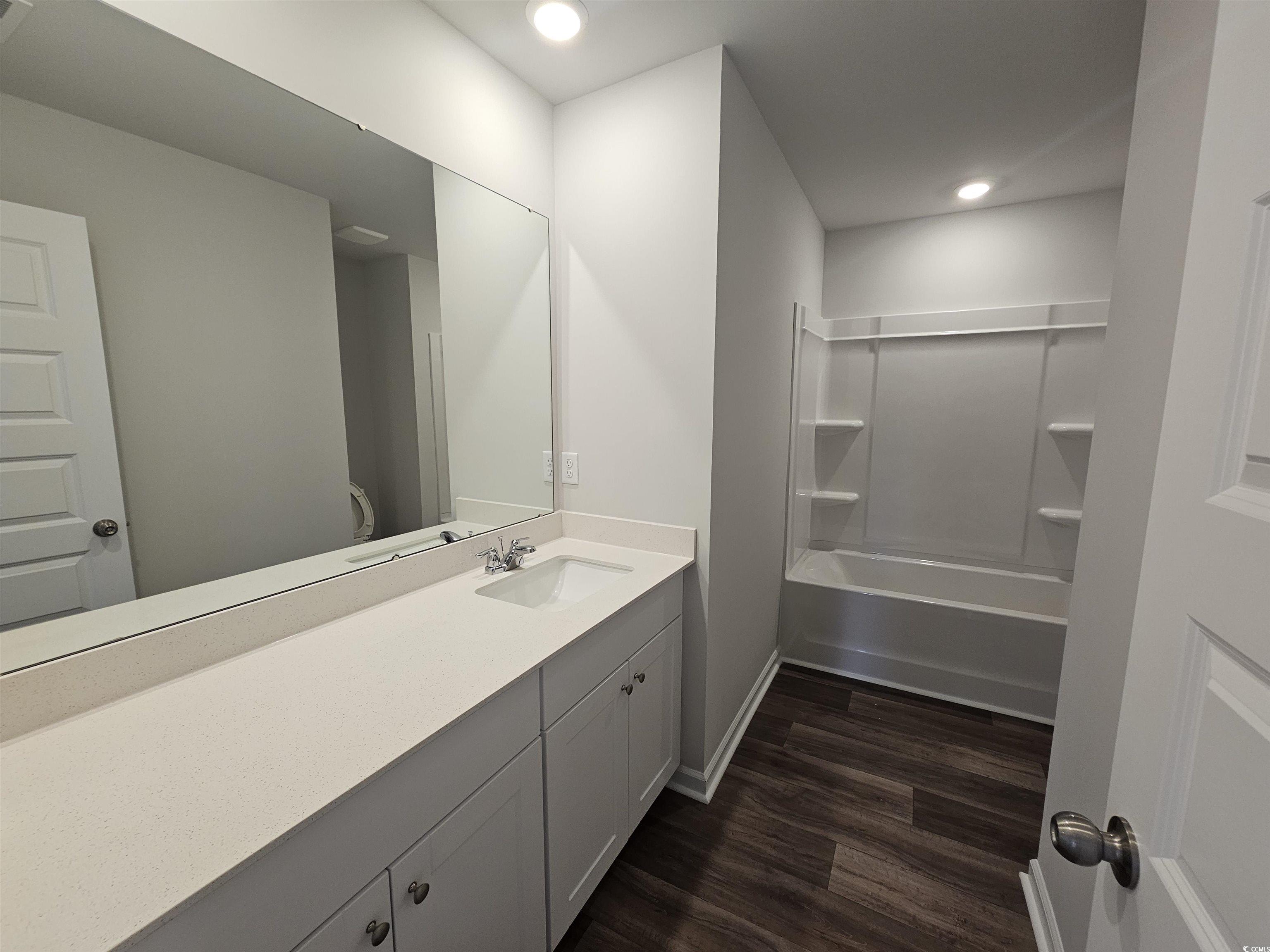 800 Wapama Street Little River, SC 29566 - Photo 22 of 34 Bathroom featuring vanity, washtub / shower combination, dark wood-type flooring, and recessed lighting
