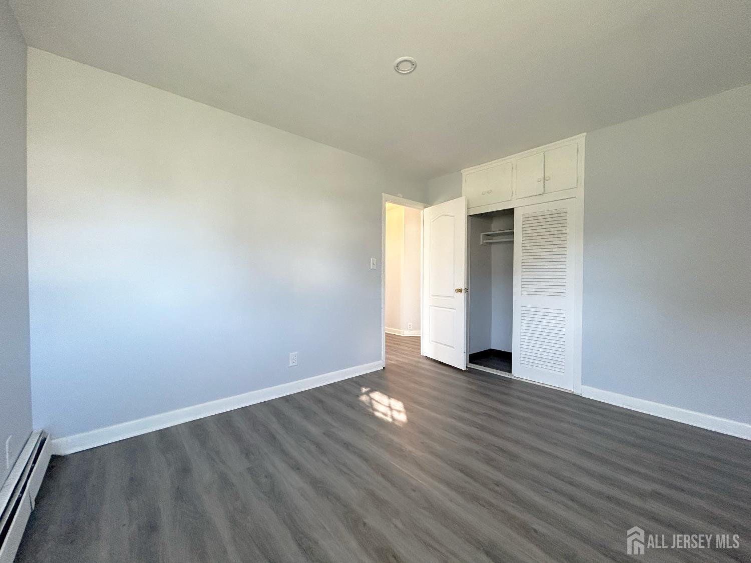 3 Stiles Road Edison, NJ 08817 - Photo 17 of 21 a view of an empty room with wooden floor and a window