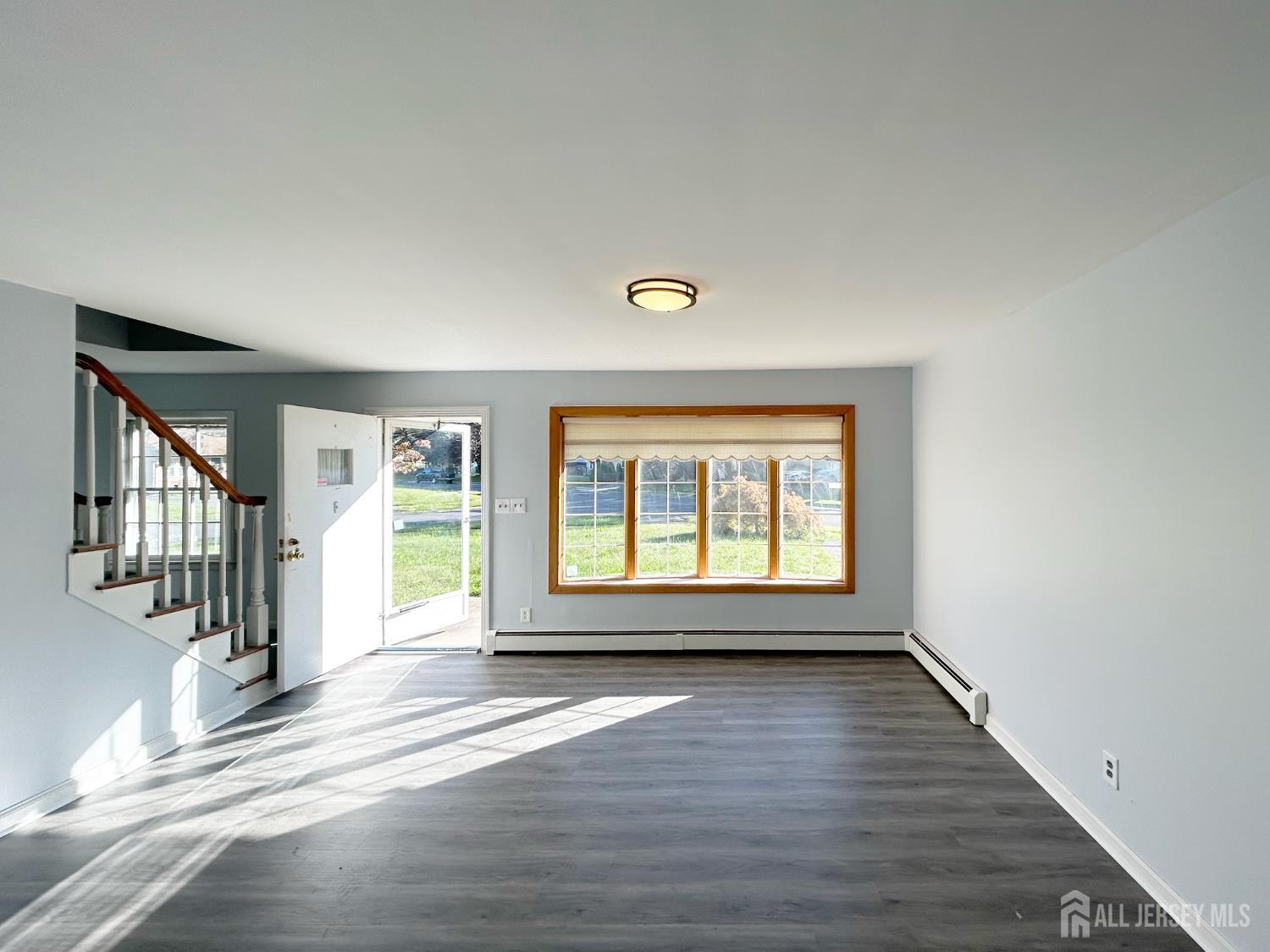 3 Stiles Road Edison, NJ 08817 - Photo 4 of 21 a view of an empty room with wooden floor and a window