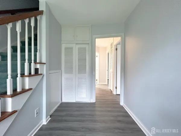 a view of a hallway with wooden floor and entryway