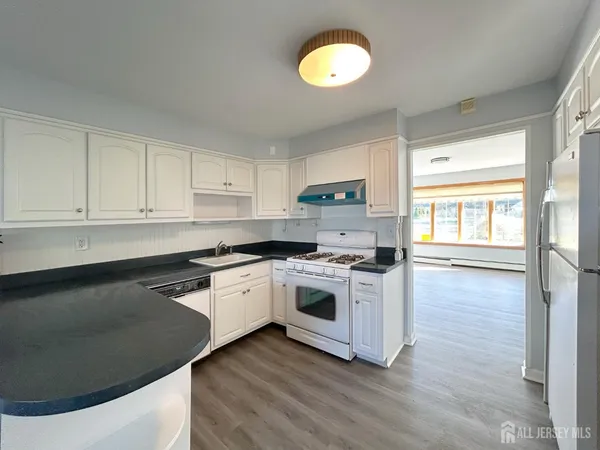 a kitchen with a stove a sink and a window