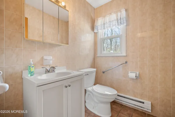 a bathroom with a sink a toilet and with window