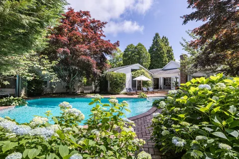 a front view of a house with yard and fountain