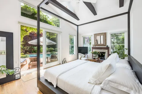 a bedroom with a bed and a large window with outer view