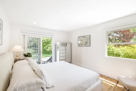 a bedroom with a bed and a large window